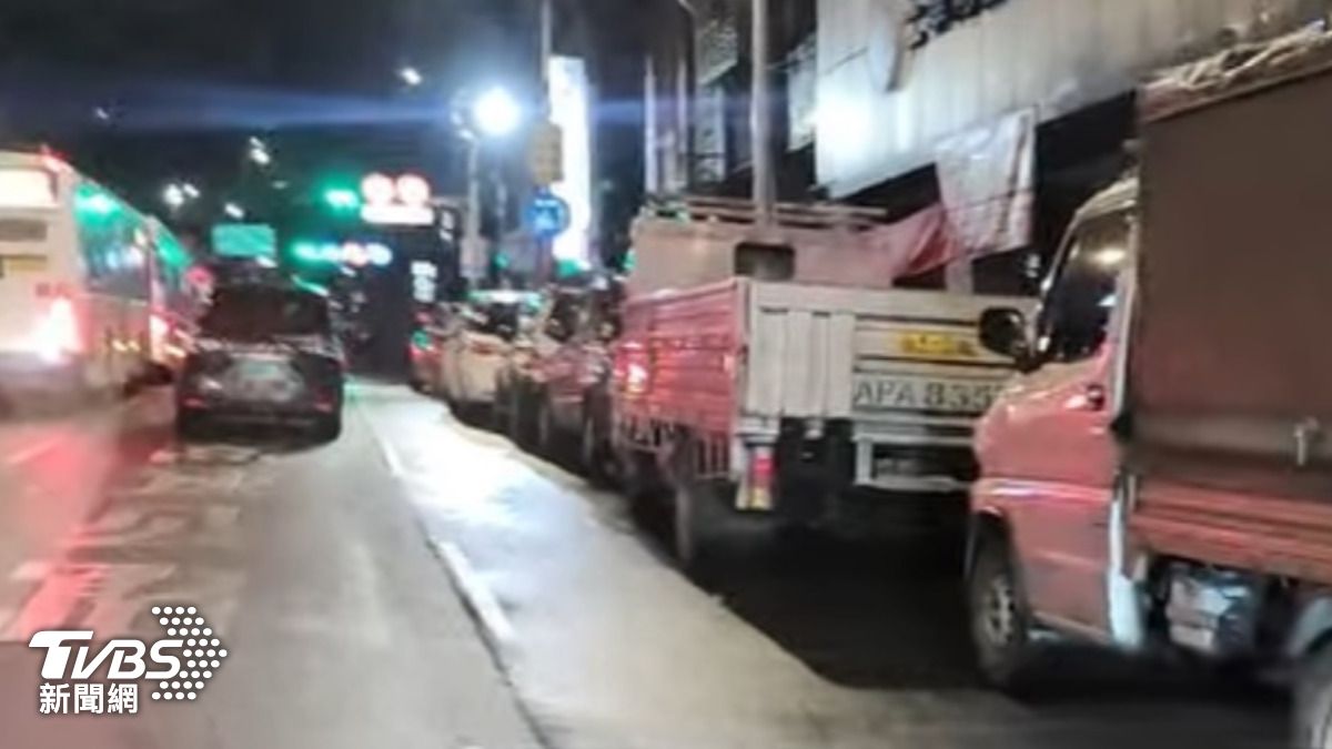 基隆孝二路深夜時段幾乎被前往漁市批貨的違停紅線車輛佔滿,造成右轉車輛,不得不往內側偏移擠進主車道,跨越了長達數十公尺的雙白實線。(圖/翻攝臉書)