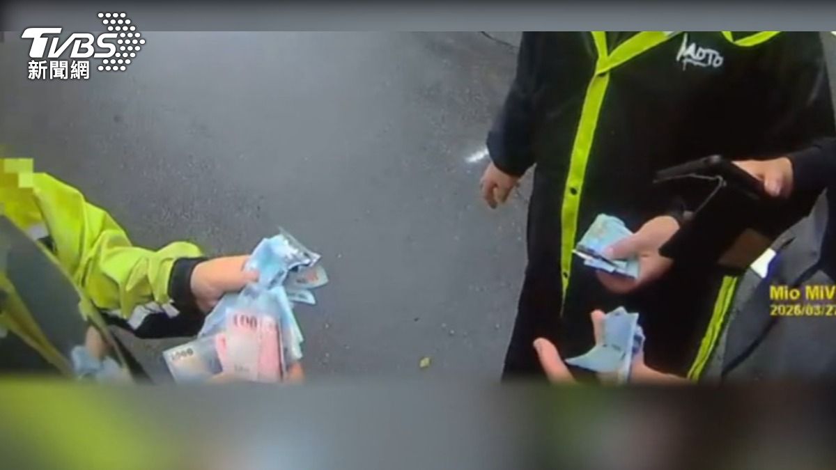 路上狂飄千元鈔!熱心騎士停車撿回,交給警察,拾金不昧。(圖/TVBS)