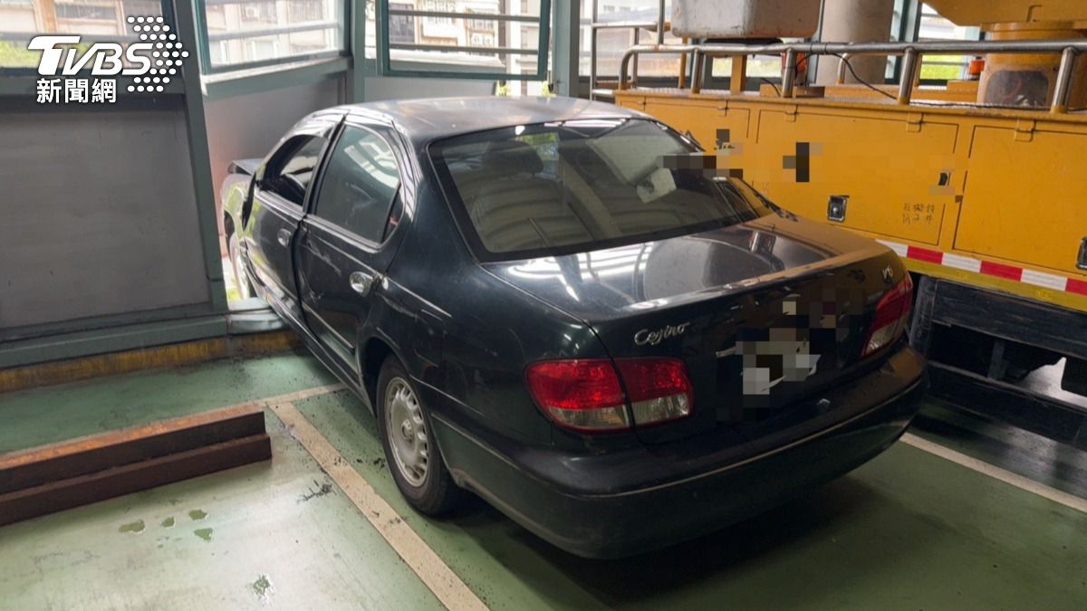 汽車暴衝撞破停車場外牆,整輛車差點「墜樓」。(圖/TVBS)