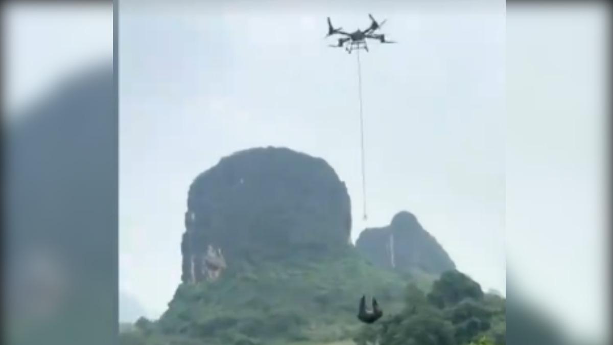 重慶一名飛手，使用農用無人機將人吊掛送上山，高度離地超過10公尺。對此大疆第一次撤銷農用無人機證照，當地警方也介入開出罰單。（圖／上海台）