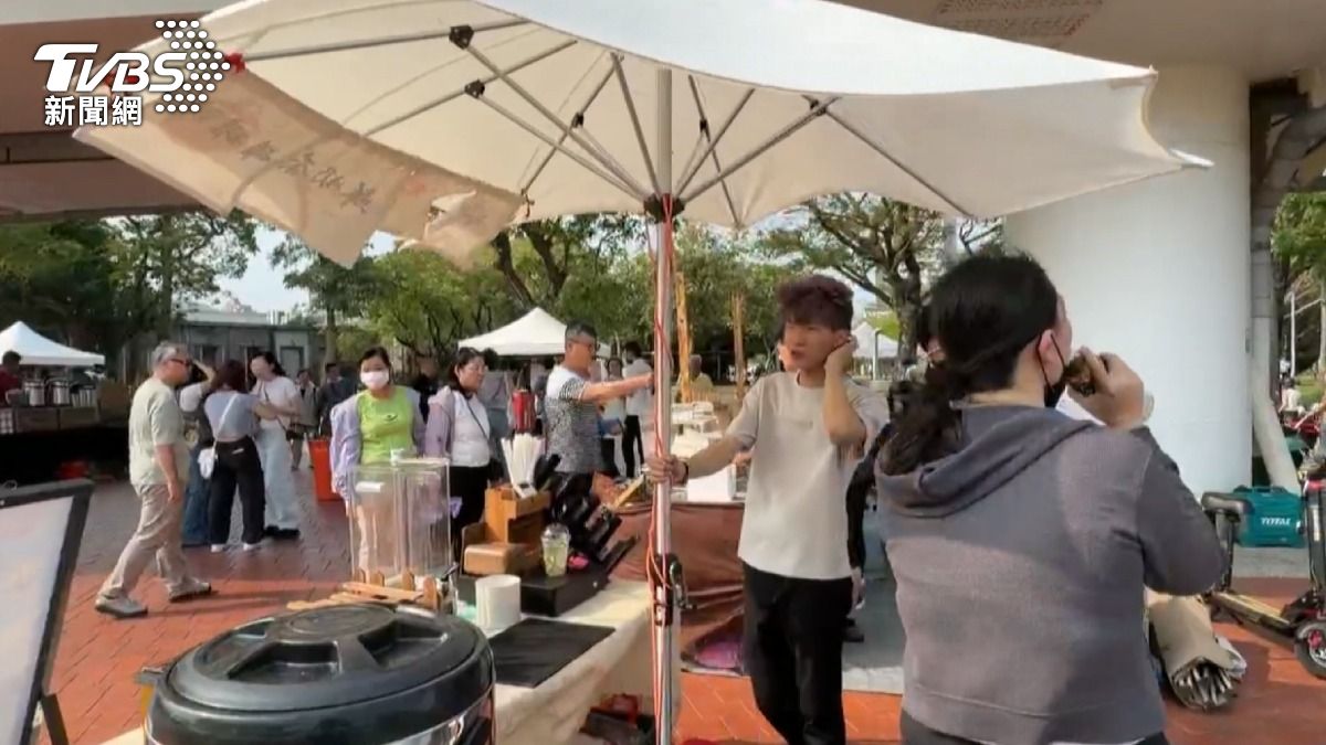 高雄駁二特區的市集也受強風影響,攤商用人力支撐大陽傘,避免吹毀。(圖/TVBS)