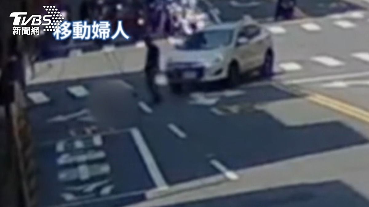 駕駛抱起受傷的婦人,移動到騎樓。(圖/TVBS)