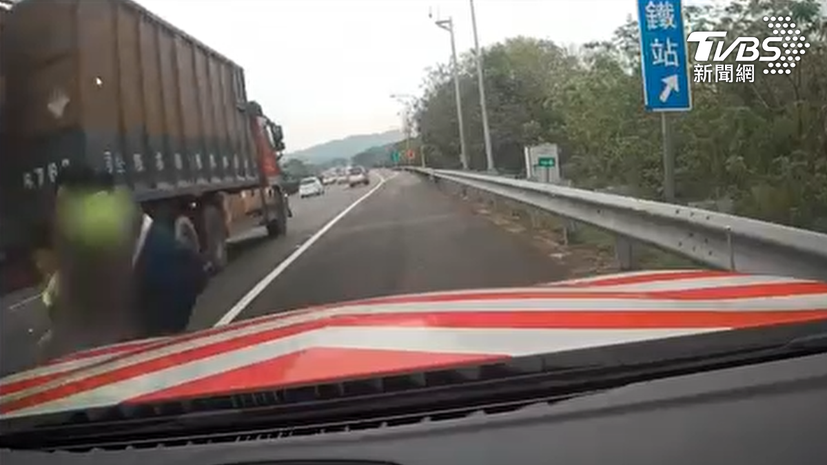 男童誤闖國道差點被經過的大貨車撞上,還好當時員警立刻下車,一把將人抱起(圖/TVBS)
