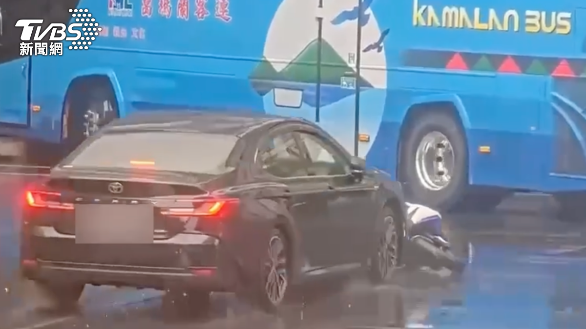 機車卡住被推撞差點在波及路過遊覽車。(圖/TVBS)