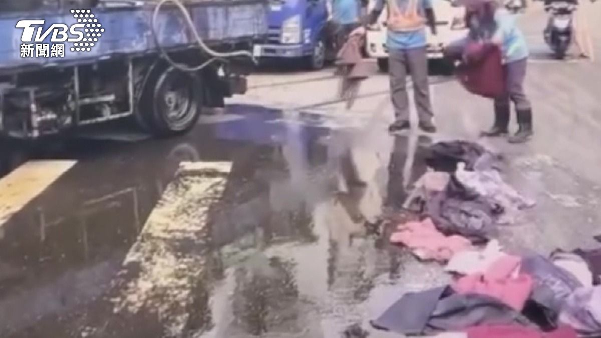 清潔隊員獲報後迅速趕抵現場,先以舊衣物鋪在地面吸油,一件一件將衣服丟到油漬上。(圖/民眾提供)