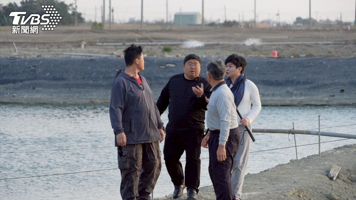 清明過後鰻魚大出,蔡易餘走在池邊,和鰻魚農討論怎麼加強行銷。(圖/柯勝雄攝)