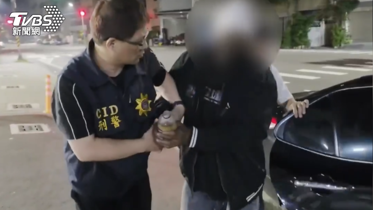 羅男落網被押上警車時還在喝飲料。（圖／TVBS）