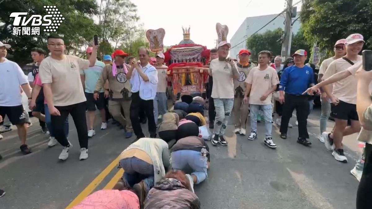 大甲媽祖遶境正式起駕，沿途「移動補給站」火力全開，業者砸30萬送蘋果，瓜農西瓜現場切，校長帶領學生專程前來「鑽轎腳」，祈求考試順利。（圖／TVBS）