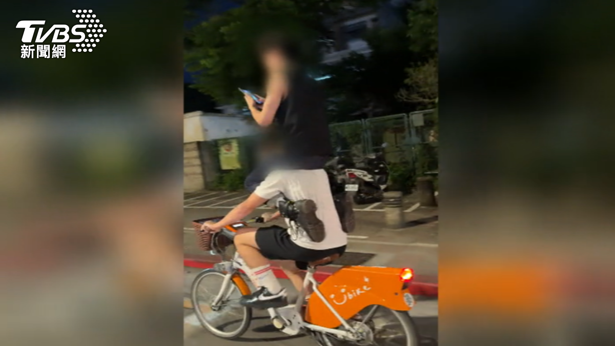 兩名男子在大馬路上疊羅漢騎YouBike還闖紅燈。（圖／TVBS）