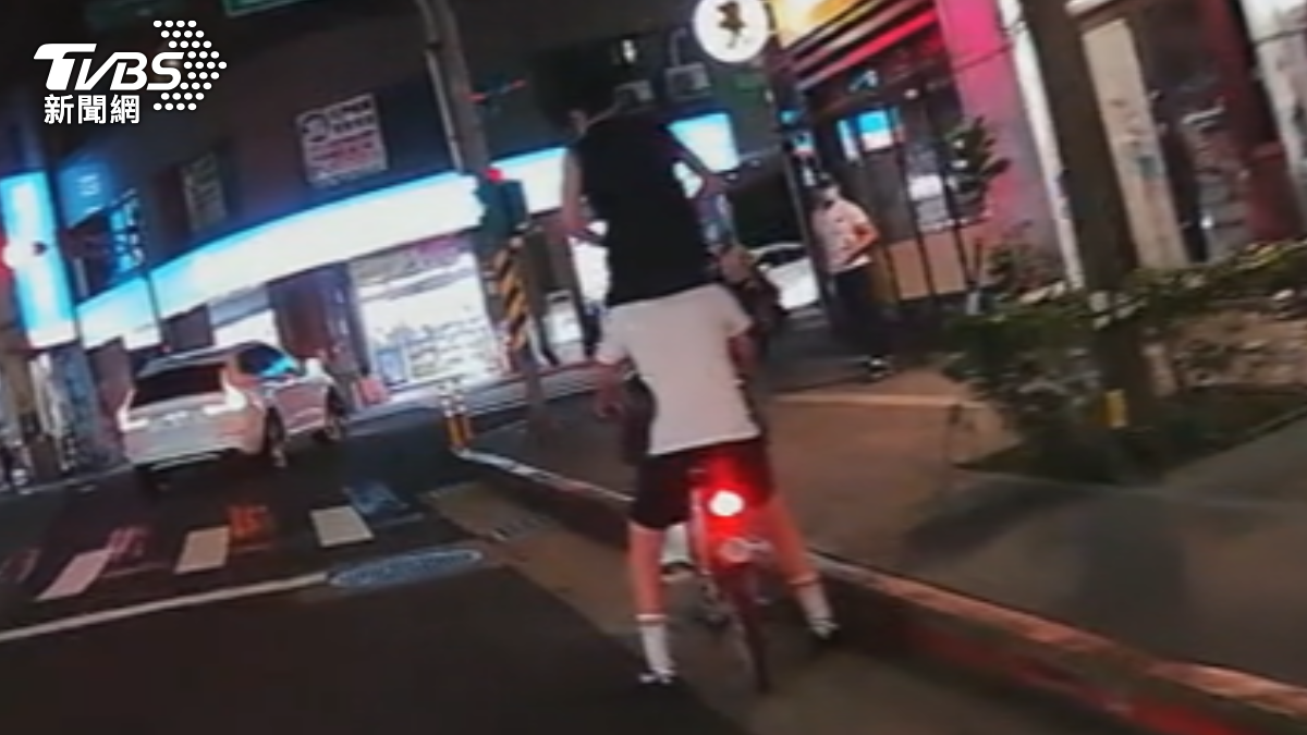 兩名男子在大馬路上疊羅漢騎YouBike還闖紅燈。（圖／TVBS）