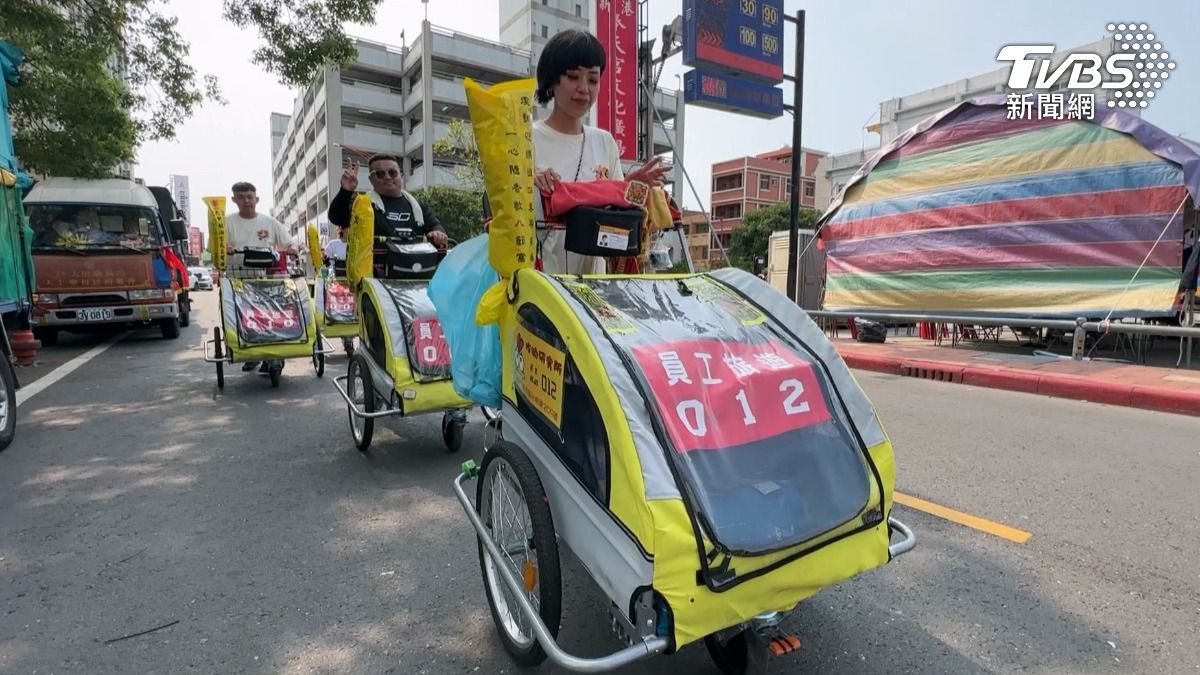 大甲媽祖遶境隊伍中出現一排整齊劃一的車隊，15輛寵物推車上頭寫著員工旅遊。（圖／TVBS）