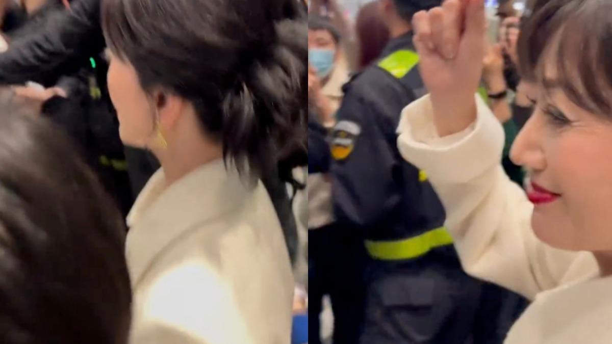 雖遭大批人群推擠,聽到粉絲呼喚她仍回頭比愛心。(圖/翻攝自微博)