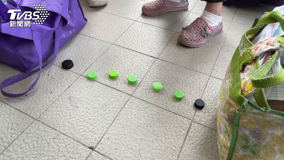 排隊過程中卻出現瓶蓋、打火機等物品占位的亂象,甚至有人疑似插隊引發不滿,險些爆發衝突。(圖/TVBS)