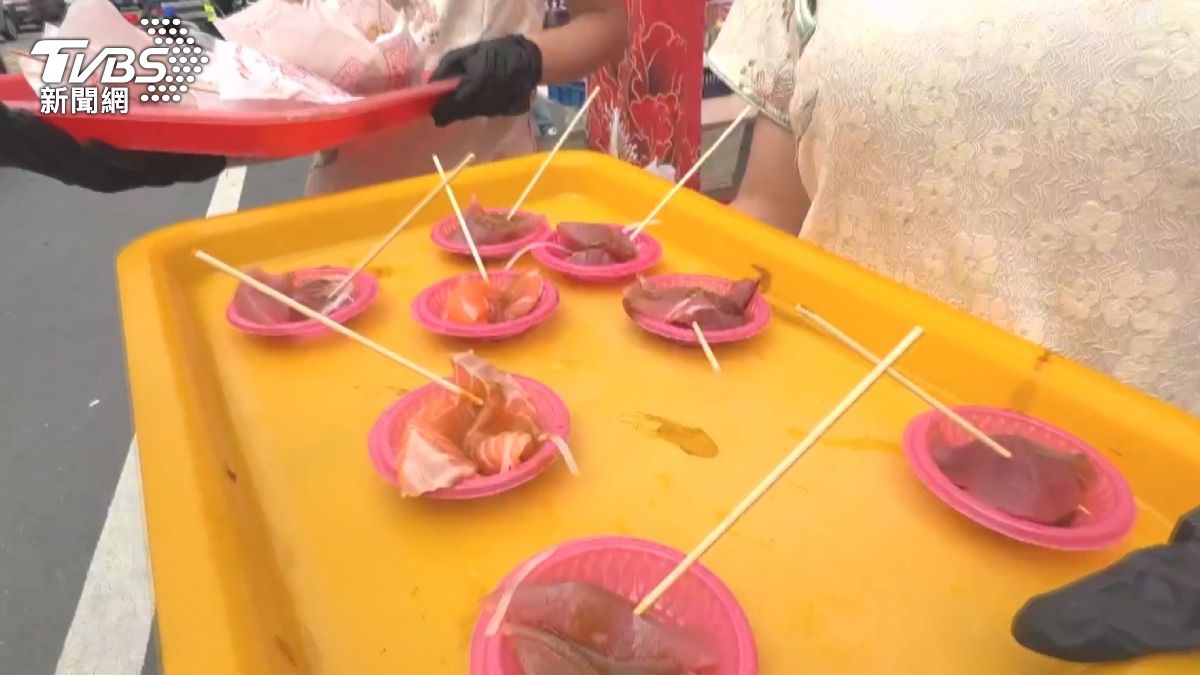 豪華點心站端出生魚片犒賞香客,準備了2隻鮭魚、2隻鮪魚現場處理,吸引眾多信眾目光。(圖/TVBS)