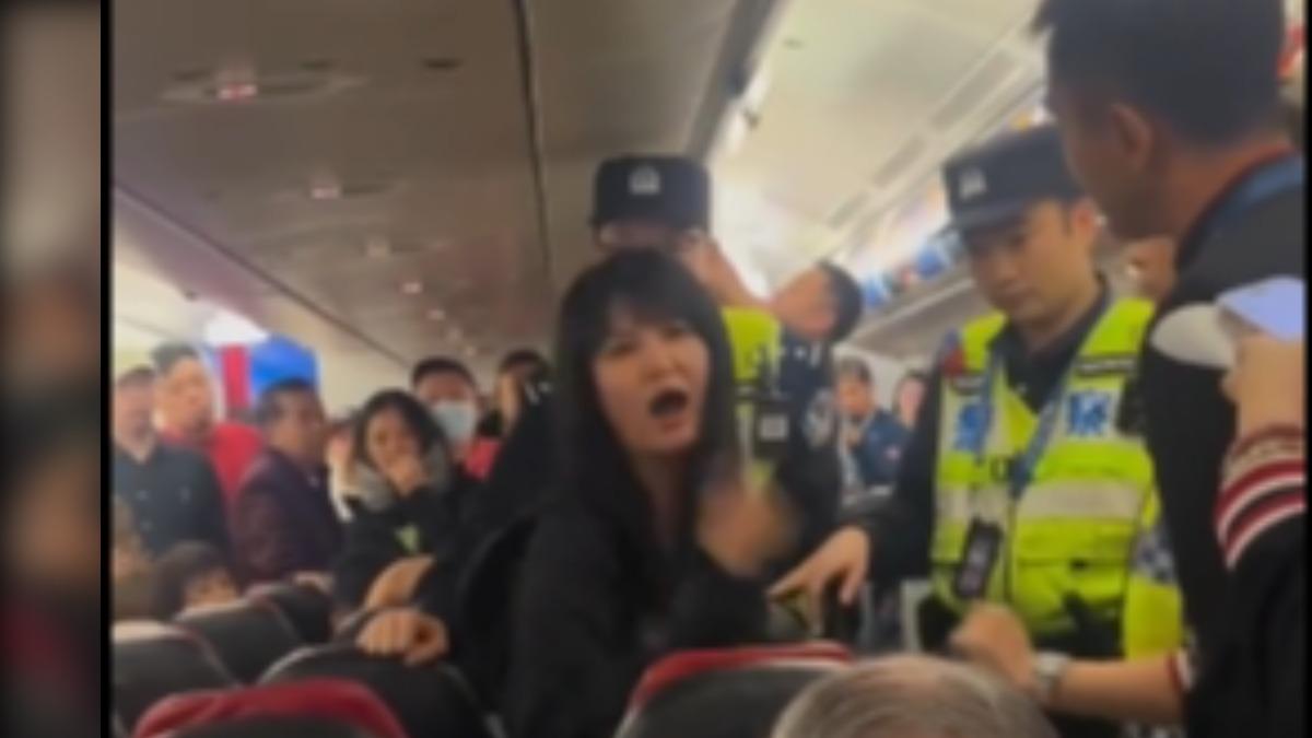 中國籍女乘客不滿亞洲航空空服員講中文,怒嗆「國際航班怎麼連中文都不會」,最終遭警方帶下飛機。(圖/微博)