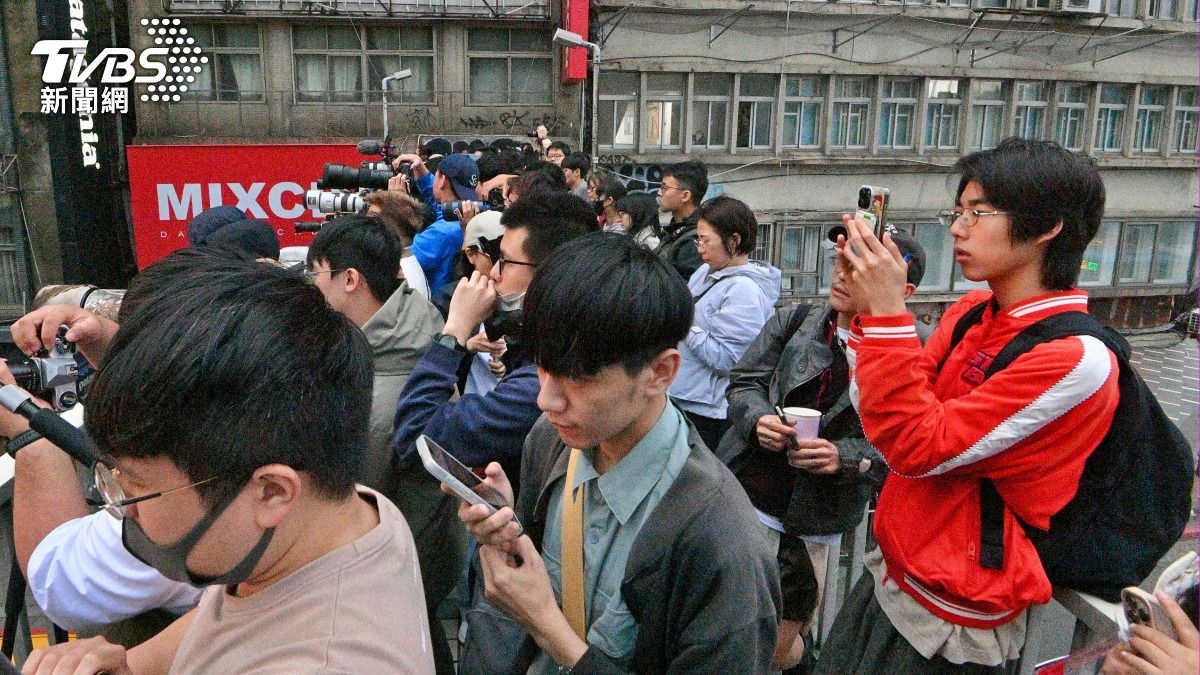 現場聚集了不少民眾拿手機及照相機拍下難得一見的台北懸日美景。(圖/胡瑞麒攝)