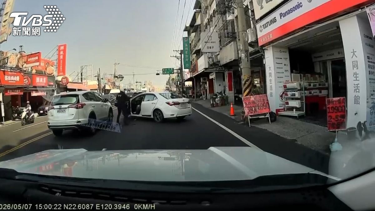 白車拒檢逃逸,還卡進車陣當中,一名員警持警棍試圖破窗。(圖/TVBS)