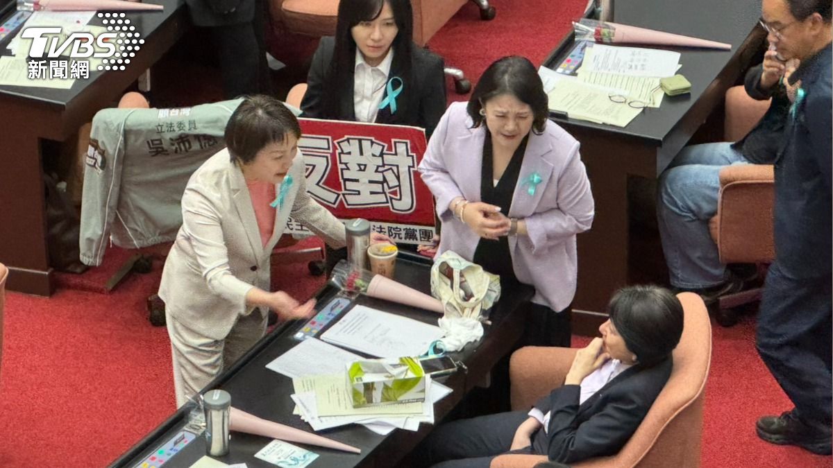 國民黨版本表決時，民眾黨立委跑到民眾黨立委邱慧洳前面「規勸」。（圖／陳怡潔攝）