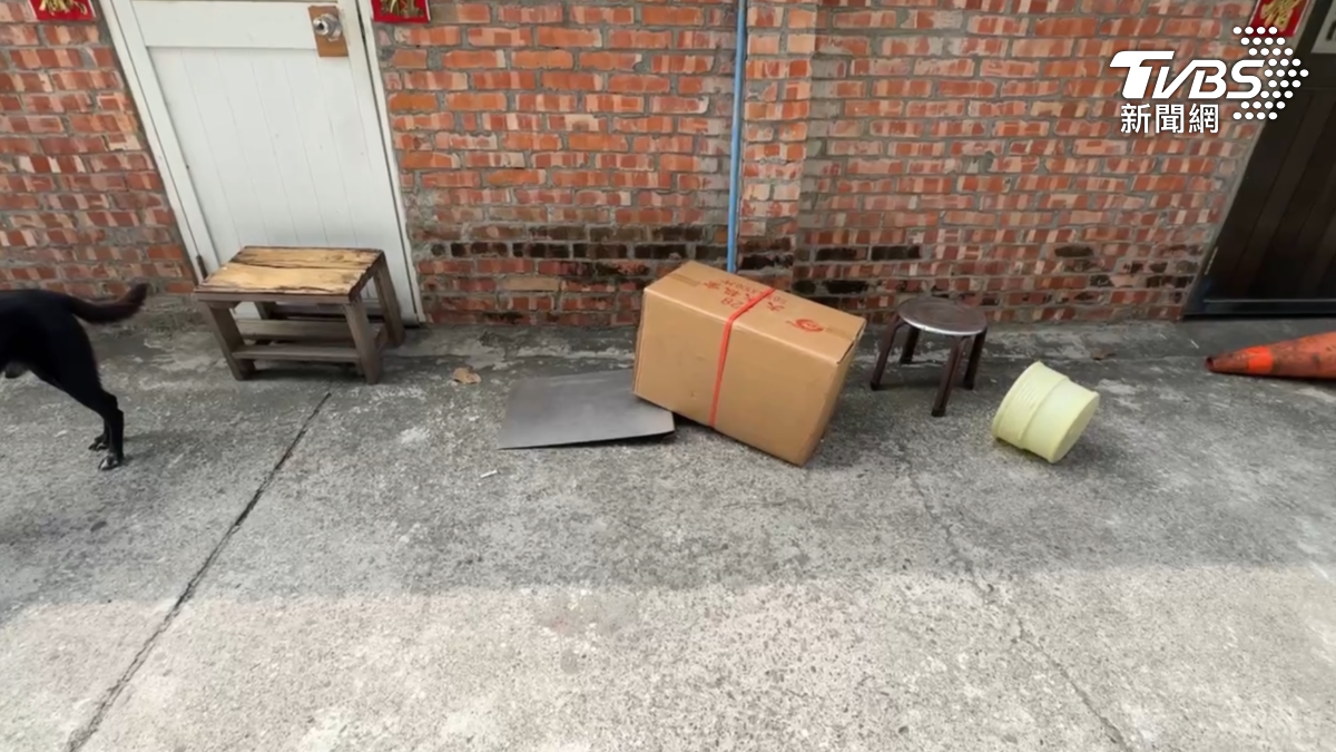 3名男子拿著三角錐、紙箱等物品,疊在住戶家門前試圖將門堵住。(圖/TVBS)
