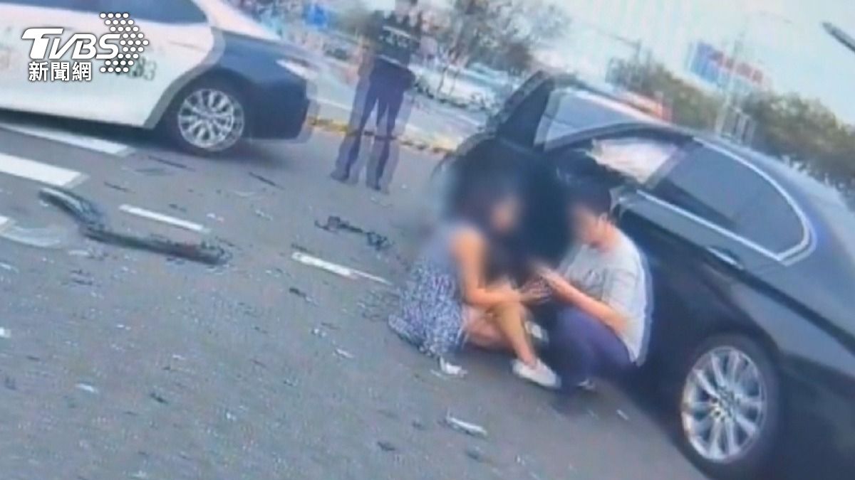 媽媽抱著兒子驚魂未定地坐在地上，旁邊已有民眾上前協助。(圖／TVBS)