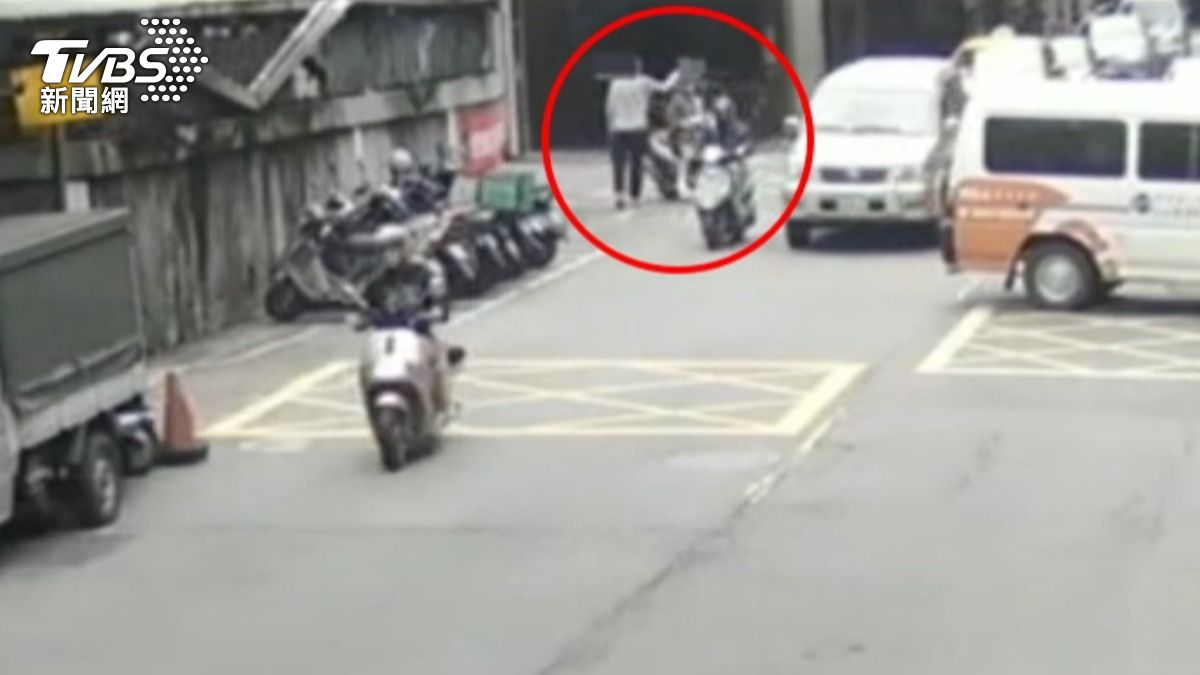 女騎士路口等車流減少通過，遭行人出手攻擊。（圖／TVBS）