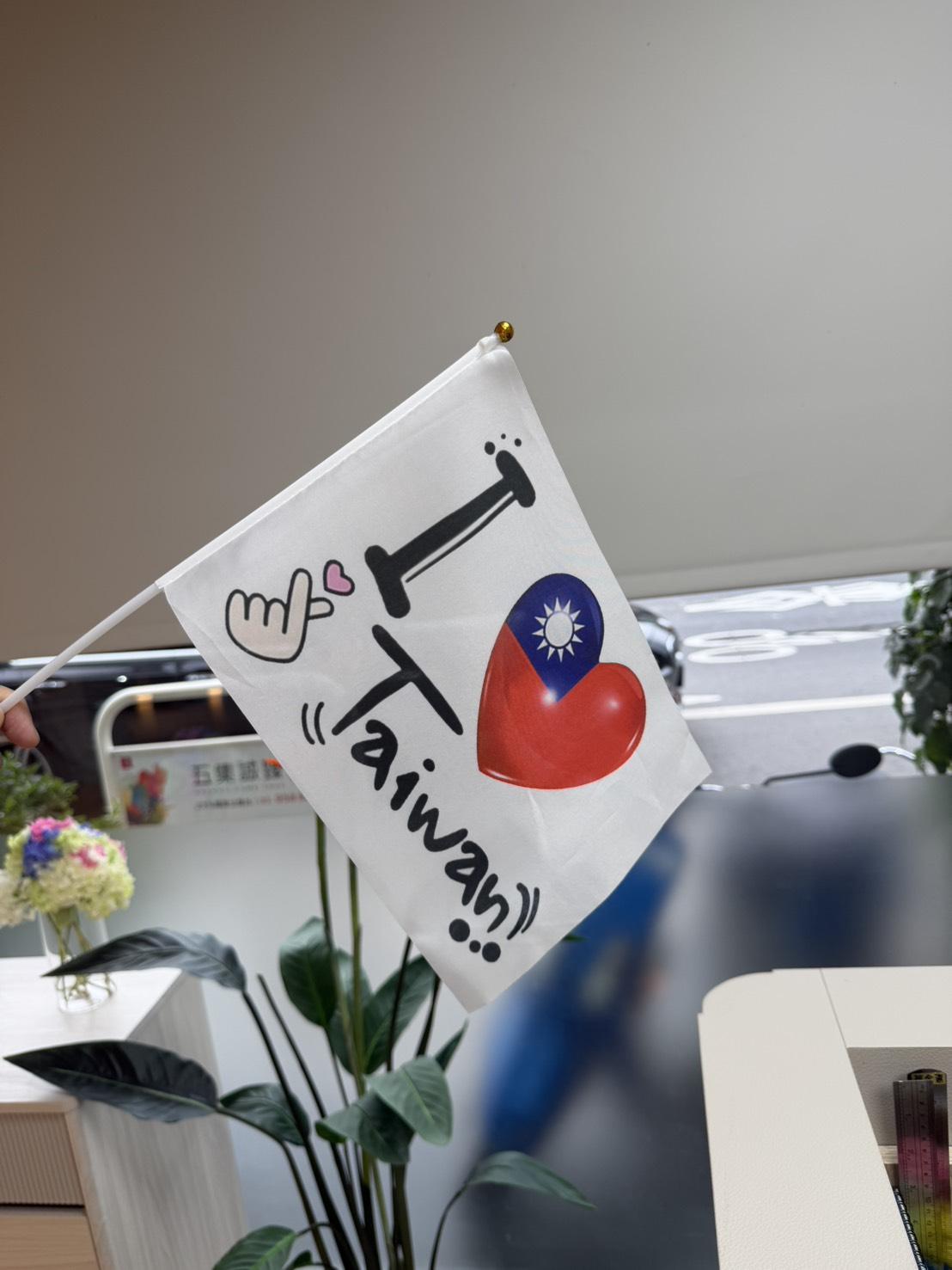 外籍女子拿著「I LOVE Taiwan」旗幟，以新台幣一百元販賣。（圖／TVBS）