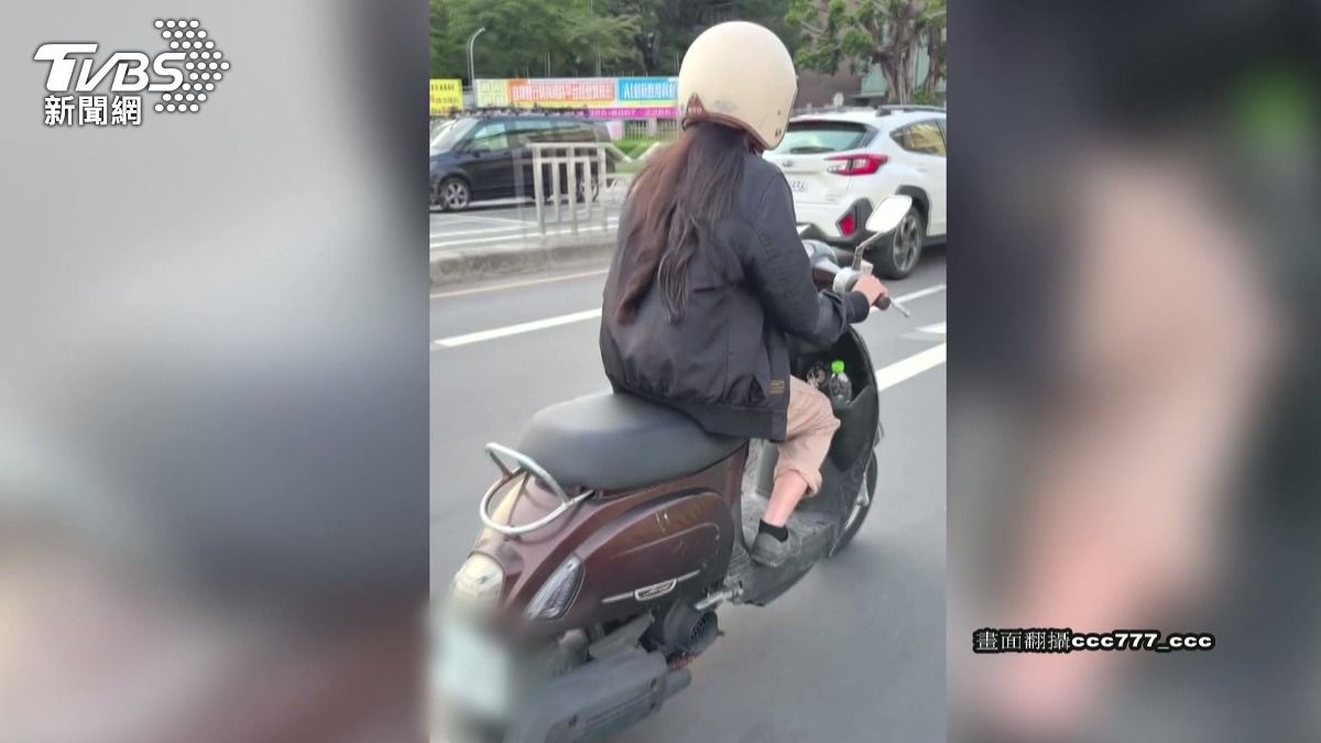 女騎士在行進中，右手握龍頭催油門，左手卻忙著滑手機，甚至用拇指操作螢幕 。(圖／民眾提供)