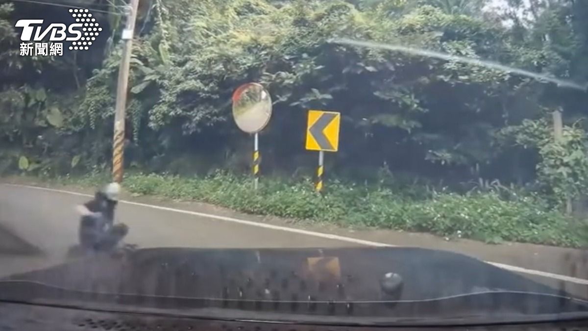 男坐滑板「用手當煞車」衝進草叢。(圖/TVBS)