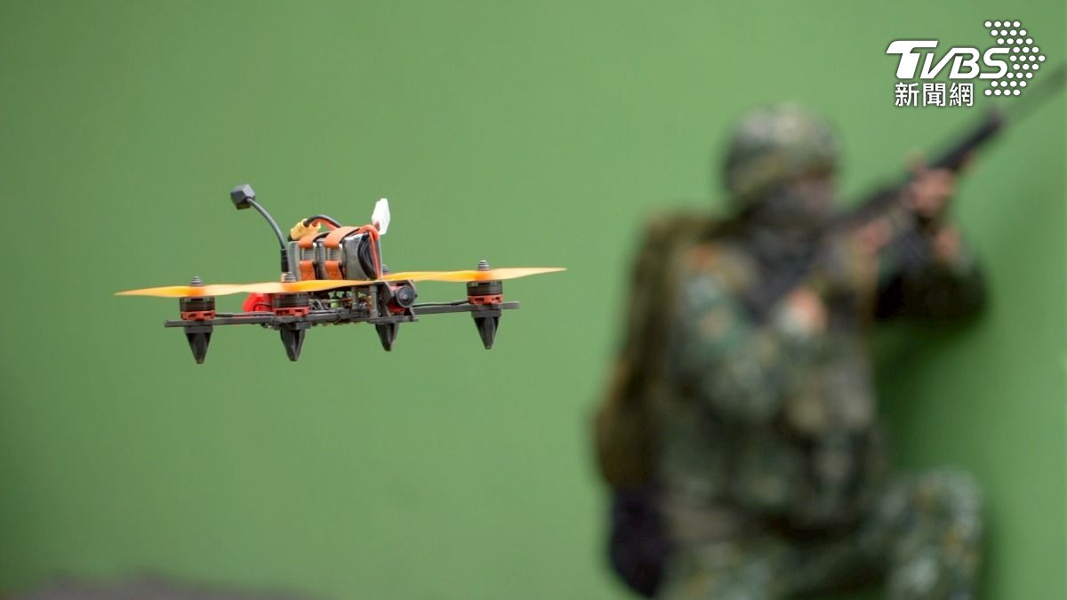 無人機升空,其他成員在一旁持長槍警戒。他們原單位不是砲指部,就是聯兵旅,學無人機後「一試成主顧」,覺得這是偵察、攻擊的好工具,同袍安全回來最重要。(圖/柯勝雄攝)