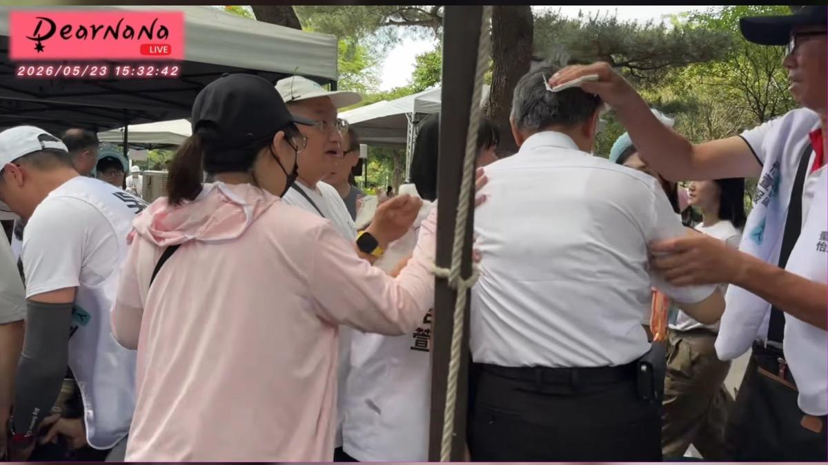 柯文哲(著白襯衫者)被砸頭後,頭髮疑似留著雞蛋液。(圖/翻攝自DearNaNa YT直播)