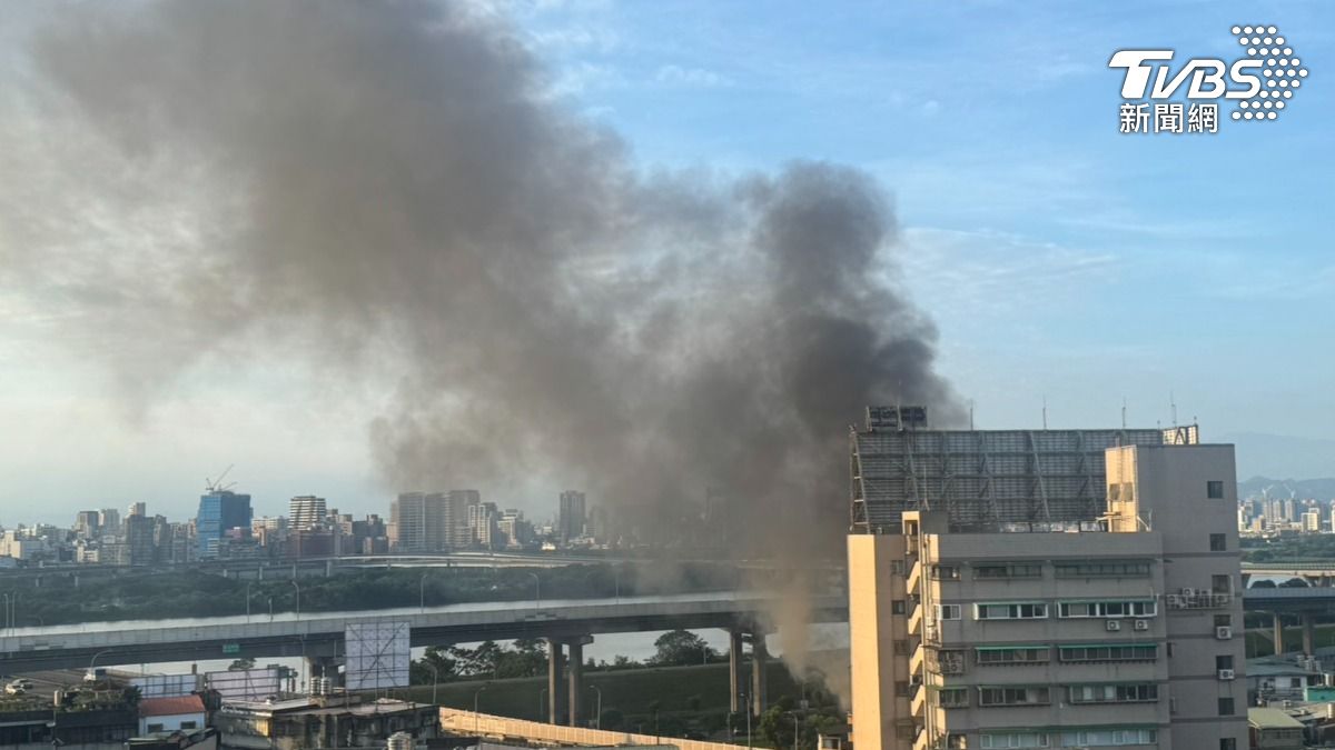火警現場位於忠孝橋下方,火場內堆放大量回收物品,火勢蔓延迅速,濃煙竄天。(圖/李昱菫攝)