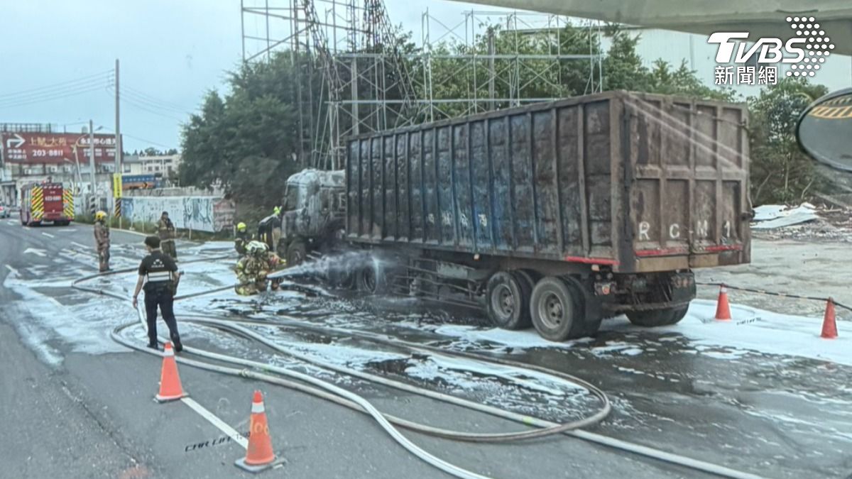 消防人員緊急佈線出水滅火,約30分鐘後控制住火勢,大貨車車頭燒成焦黑。(圖/TVBS)