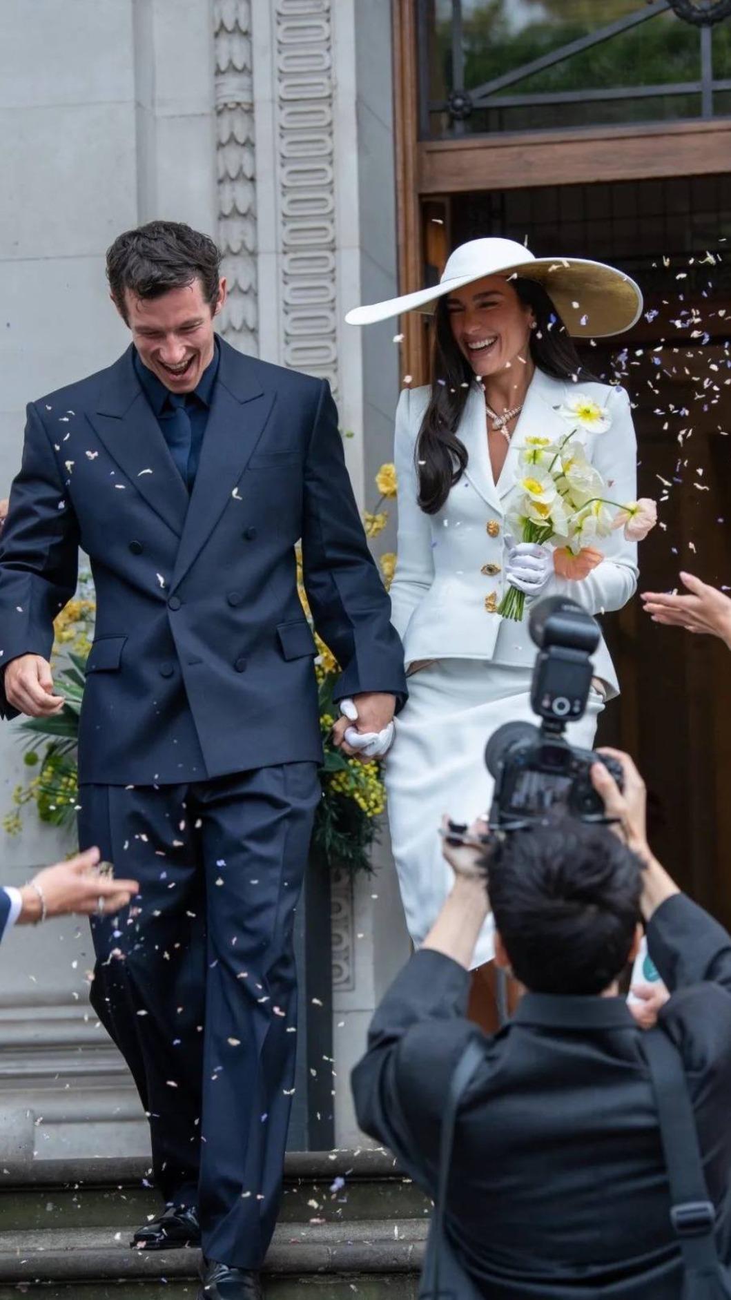杜娃黎波昨在倫敦登記結婚並舉行小型儀式,好友們向小倆口噴灑紙花。(圖/翻攝自《daily mail》)