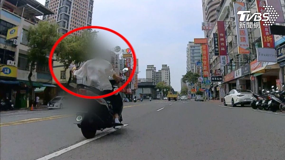 高雄三民區義華路日前出現一名騎乘機車的男子，蛇行闖紅燈，未戴帽揮法器狂飆，讓後方騎士看得膽戰心驚，立即報警處理。（圖／TVBS）
