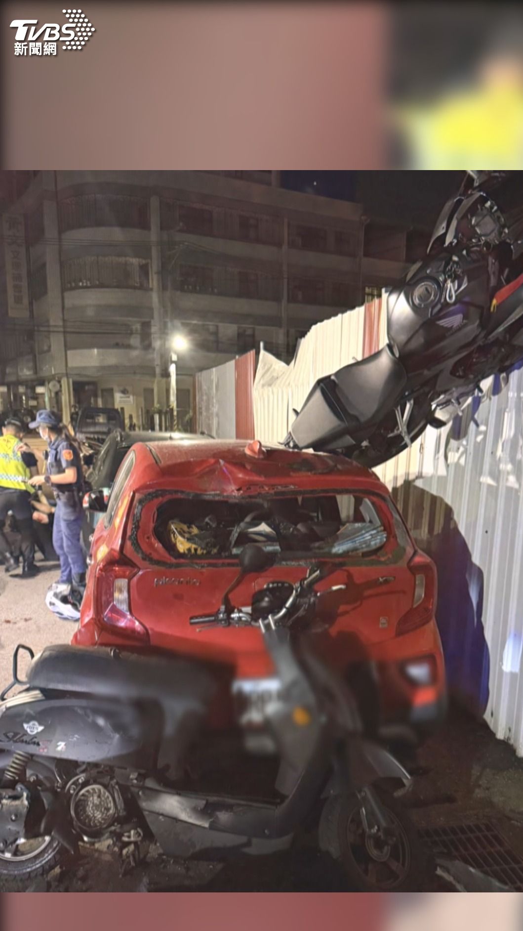 重機撞車彈飛到卡在鐵皮圍籬上,形成車在牆上,人摔飛在地上的離奇車禍(圖/TVBS)