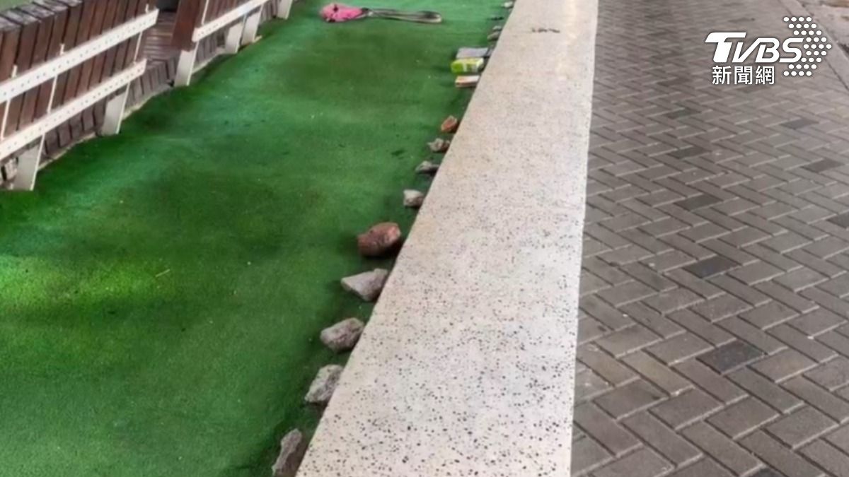 公園花圃裡的每顆石頭象徵排隊領便當人潮。(圖/TVBS)