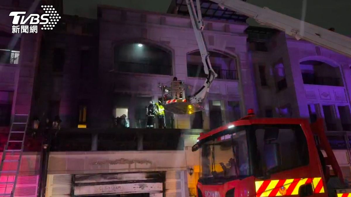 消防人員為他們戴上共生面罩防護煙毒，隨後引導民眾登上雲梯車升降梯，受困的3名民眾皆成功脫困。（圖／TVBS）