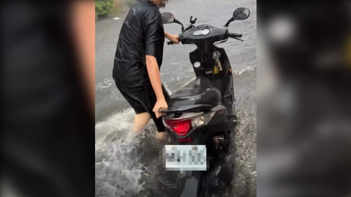 新北蘆洲地區水淹小腿,民眾只能涉水牽車,寸步難行。(圖Threads/aries2001_04)