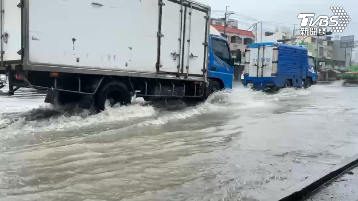 短時間強降雨造成低窪地區迅速積水,車輛經過時濺起的水花宛如人造浪一般。(圖/TVBS)