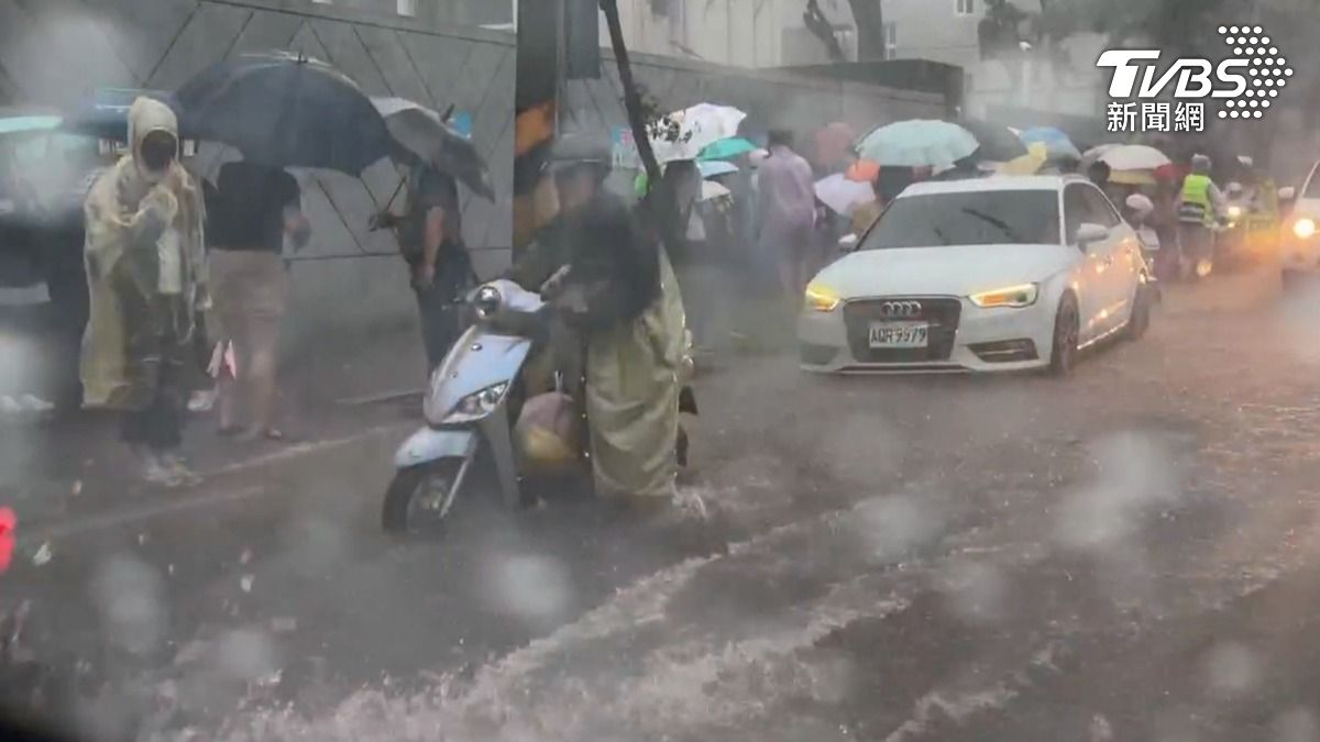台南午後暴雨狂襲,五妃街「5分鐘淹成河」由於剛好遇到下課時間,還有不少家長在水中接送小孩。(圖/TVBS)