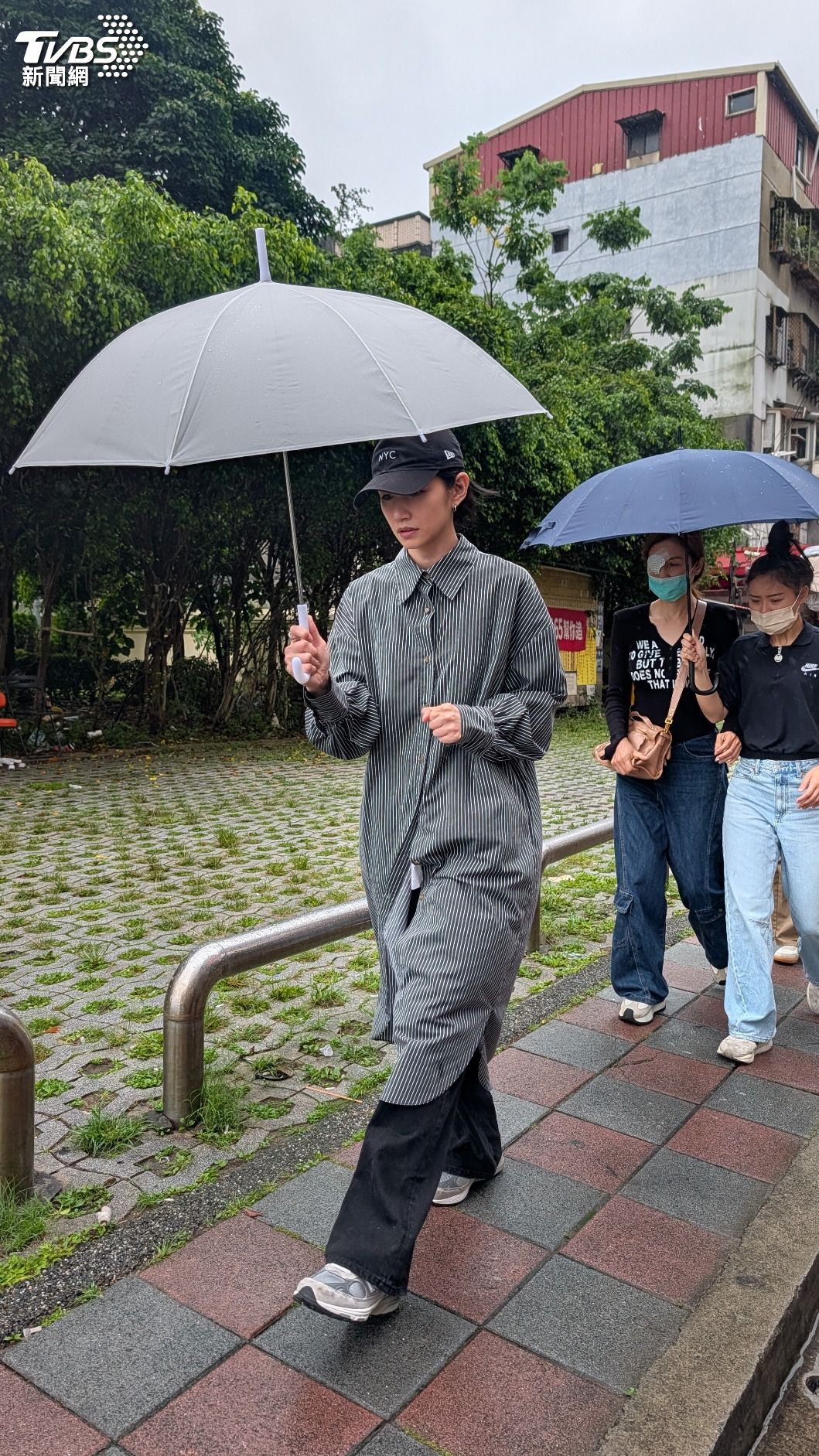 李千娜(左)雨中送行。(圖/趙世平攝)
