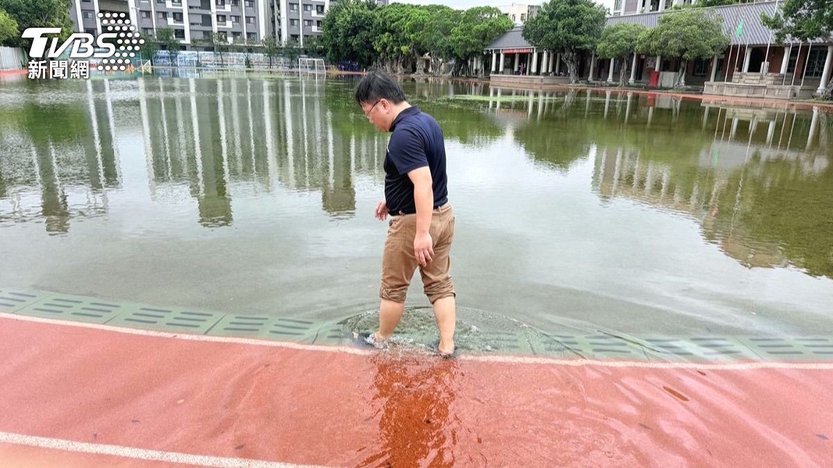 清水國小操場慘變「泳池」，從草皮走過去還得捲起褲管，積水已深及小腿。(圖／TVBS)