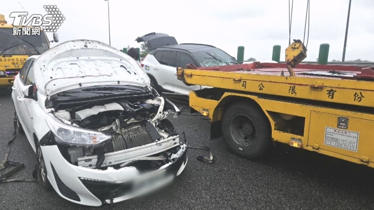 黑色車輛駛來時,以S型路線閃避掉落物與警示架,但隨後內線又駛來一輛白色車輛,直接撞上拖吊車車尾。(圖/TVBS)