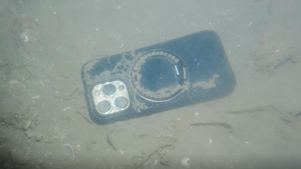 這隻iPhone手機被打撈上岸後,螢幕不但還會亮,而且還能正常通話。(圖/TVBS)