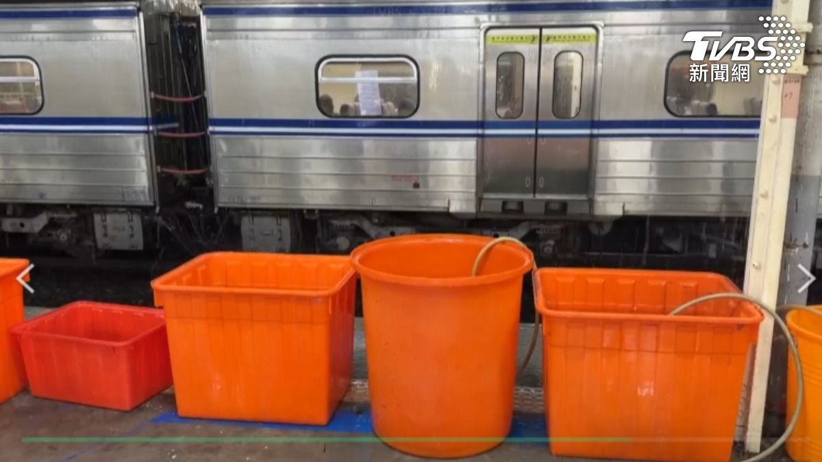 台南市晚間一陣強降雨,火車站月台用大小水桶接水,戶外民眾撐傘淋雨排隊轉乘。(圖/TVBS)