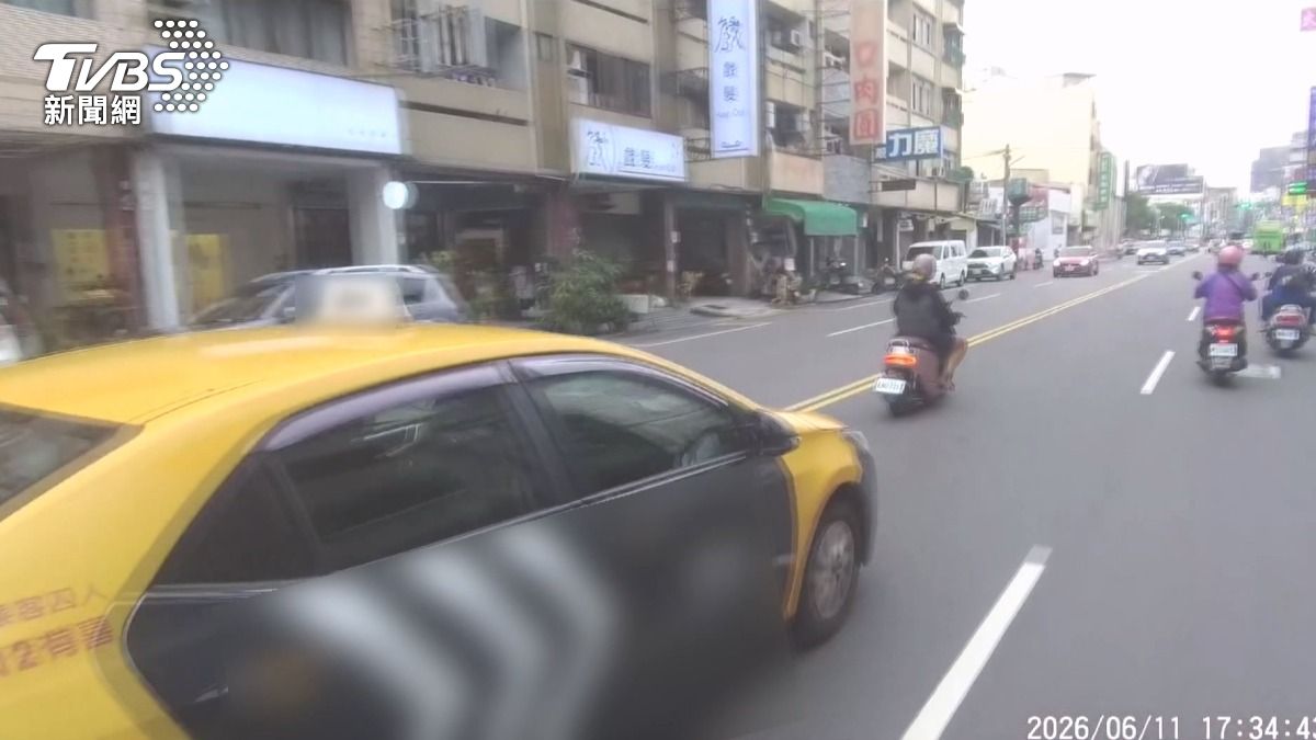計程車突然打了方向燈就想往右切,機車騎士被嚇到,趕緊往右閃避,差點發生碰撞。(圖/民眾提供)