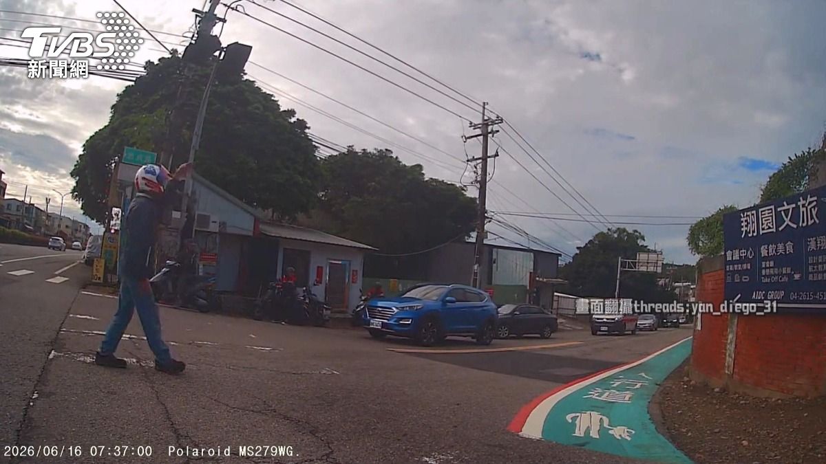 救護車鳴笛遭藍車擋路!熱心騎士衝下車指揮,駕駛進退兩難惹議。(圖/民眾提供)
