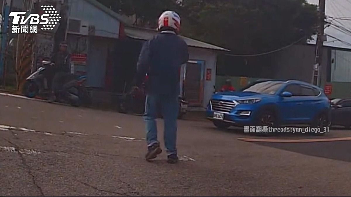 藍色休旅車停等紅燈時未禮讓,導致救護車無法通過,所幸熱心機車騎士主動下車指揮交通。(圖/民眾提供)