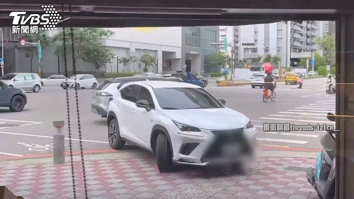 台中違停糾紛!進口車霸人行道 駕駛搧手機「罰單比停車費貴」。(圖/民眾提供)