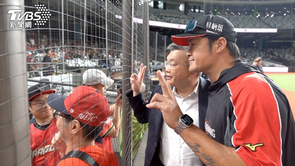 才引退不久的球星林智勝,現在是味全龍的助理打擊教練。他遠遠看到蔡其昌的背影,就跑過來陪他和球迷拍照。(圖/柯勝雄)